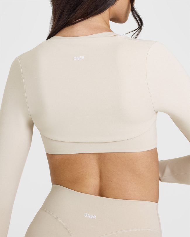 SoftMotion™ Long Sleeve Shrug with White Logo | Sand