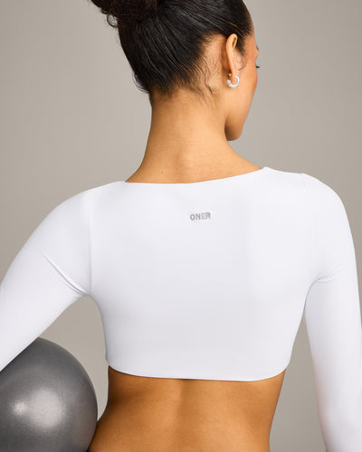 SoftMotion™ Scoop Neck Long Sleeve Crop Top with Built in Bra Shelf with Grey Logo | White