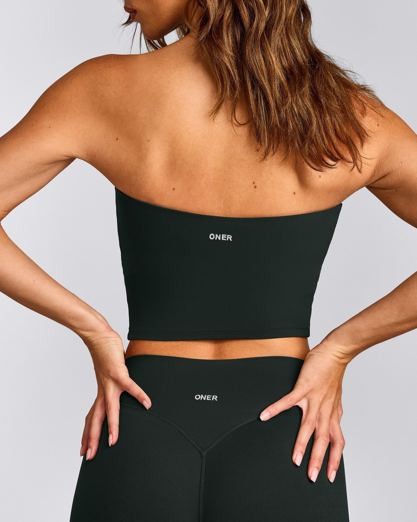 SoftMotion™ Bandeau Mid Vest with Built in Bra Shelf with Grey Logo | Emerald Noir