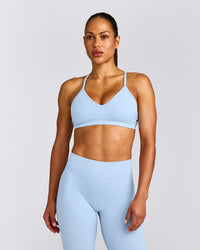 EnhanceLift™ Seamless Strappy Sports Bra with Gray Logo | Powdered Blue